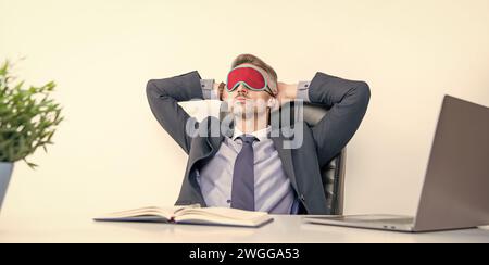 Müde Manager entspannen in Schlafmaske am Arbeitsplatz Stockfoto