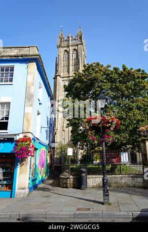 GLASTONBURY, Großbritannien - 5. September 2023 - Blick auf den Kirchturm St. John the Baptist entlang der High Street mit einem schmiedeeisernen Schild am Hanover Square im Vorhang Stockfoto