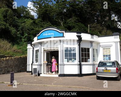 Dame am Eingang zum Hideaway Café entlang der Promenade, Seaton, Devon, Großbritannien, Europa. Stockfoto