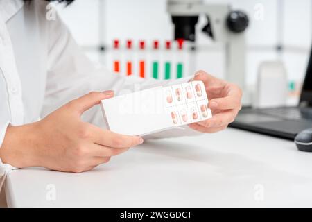 Frau im Labor untersucht die Qualität von pharmazeutischen Kapseln Stockfoto