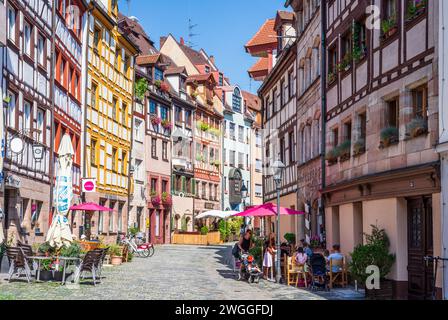 Die Weißgerbergasse ist eine Fußgängerzone in der Altstadt von Nürnberg, berühmt für ihre Fachwerkhäuser, gesäumt von Straßencafés. Stockfoto