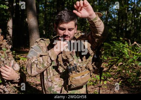 Elite-Soldat strahlt zielgerichtete Entschlossenheit und Bereitschaft aus, vorbereitet für eine gefährliche Militäroperation, die das Wesen von Mut und einfängt Stockfoto