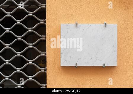 Leeres Schild aus weißem italienischem Marmor an einer Ladenfassade Stockfoto