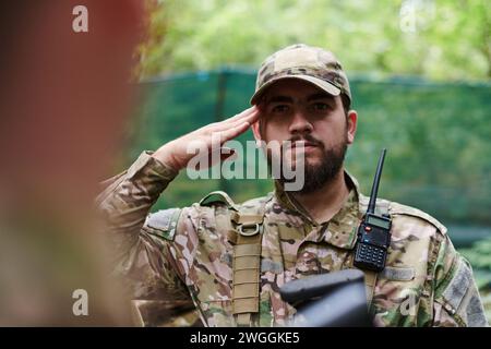 Ein engagierter Soldat grüßt seine Eliteeinheit und zeigt Kameradschaft und Bereitschaft für die gefährlichsten militärischen Operationen Stockfoto