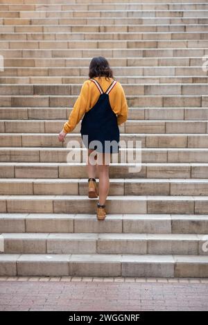 Frau mit Rückansicht, die draußen die Treppe hinaufgeht Stockfoto
