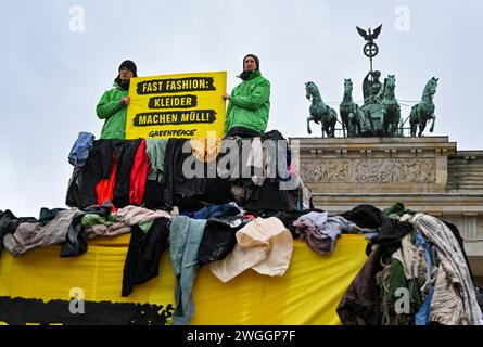 Berlin, Deutschland. Februar 2024. Unter dem Motto „Fast Fashion: Clothes make Garbage!“ protestieren Greenpeace-Aktivisten vor dem Brandenburger Tor gegen die Umweltverschmutzung in Ghana durch Fast Fashion-Kleidung als Plastikmüll. Am selben Tag beginnt die Fashion Week in Berlin. Quelle: Jens Kalaene/dpa/Alamy Live News Stockfoto