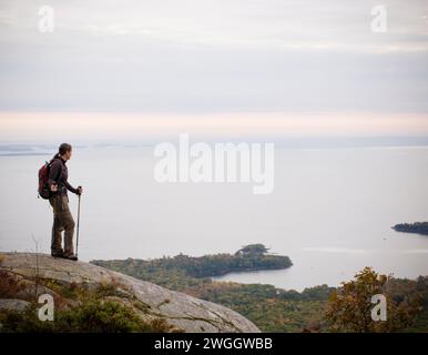 Eine junge Wanderin blickt über Penobscot Bay, Maine. Stockfoto