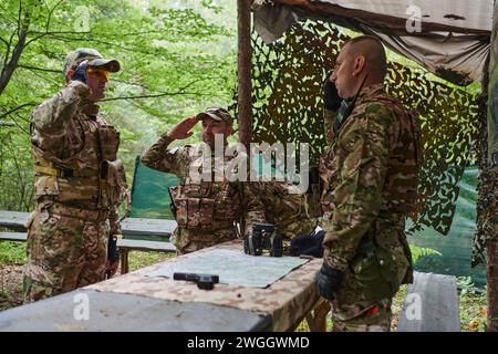 Eine gut ausgebildete Militäreinheit organisiert eine taktische Mission, während sie während einer Besprechung eine Militärkarte studiert Stockfoto