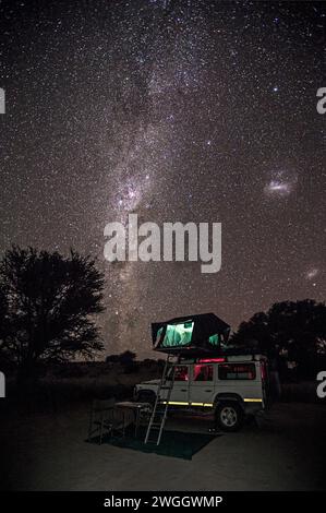 Geländewagen mit ausklappbarem Zelt unter Sternenhimmel bei Nacht, Kalahari-Wüste, Namibia Stockfoto