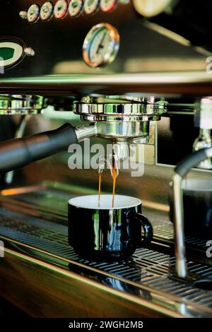 Nahaufnahme des Espresso-Ausgießens aus der Kaffeemaschine – Stockfoto Stockfoto