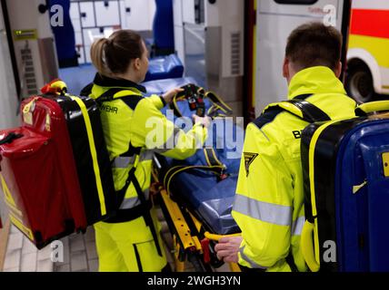 München, Deutschland. Februar 2024. Feuerwehrleute der Feuerwehr München bereiten einen Krankenwagen für einen Einsatz in der Fahrzeughalle der Feuerwehr 1 vor. Quelle: Sven Hoppe/dpa/Alamy Live News Stockfoto