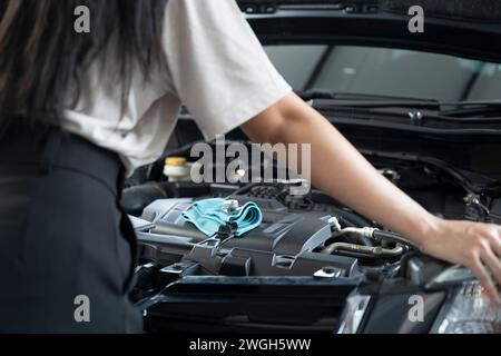 Asiatische Frau, die Probleme mit ihrem Auto hat schöne Frau, die kaputte Autos inspiziert, bevor sie zu Hause geht. Stockfoto