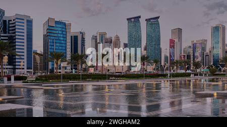 Skyline von Doha in der westlichen Bucht Doha, Katar Nachmittagsaufnahme aus dem Hotelpark mit künstlichem See im Vordergrund und Wolken im Himmel im Hintergrund Stockfoto