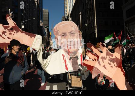 New York, Usa. Februar 2024. Ein Pappausschnitt von Benjamin Netanjahu, Premierminister, Israel mit Blut, das aus seinen Mundwinkeln austritt und auf sein Hemd tropft, zusammen mit blutverschämten Händen bei einer Kundgebung zur Unterstützung Palästinas und gegen die Durchsetzung von Gesetzen durch das NYPD, die Demonstranten daran hindern, elektronische Tonsysteme ohne Erlaubnis zu nutzen. (Foto: Derek French/SOPA Images/SIPA USA) Credit: SIPA USA/Alamy Live News Stockfoto