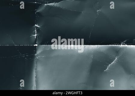Dunkler blauer zerknitterter Papierhintergrund mit rauen Falten und geometrischen ausgefransten Falten. Abstrakter alternder grungy trendiger Hintergrund Stockfoto