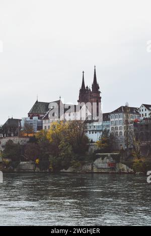 Gebäude mit dem Dom im Hintergrund am rheinufer in Basel, Schweiz am 17. November 2019 Stockfoto