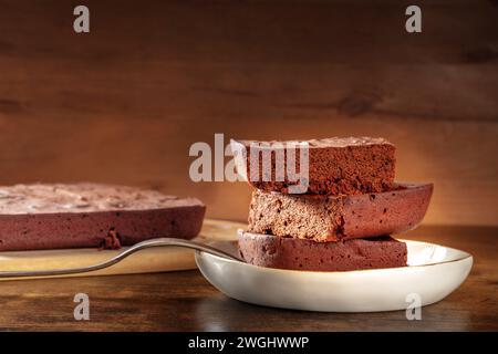 Schokoladenbrownie, einfacher Kaffeekuchen, ein Seitenblick auf einem dunklen rustikalen Holzhintergrund mit Kopierraum Stockfoto