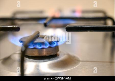 Gaskocher in der Küche. Blaue Flammen auf Gasherd-Brenner zu Hause. Nahaufnahme des brennenden Feuers auf dem Propangaskocher. Stockfoto