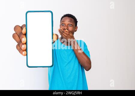 Ein schwarzer Mann zeigt seinen Telefonbildschirm und sieht überrascht aus Stockfoto
