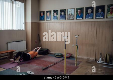 Kiew, Ukraine. Dezember 2023. © Adrien Vautier/Le Pictorium/MAXPPP - Kiew 05/12/2023 Adrien Vautier/Le Pictorium - 05/12/2023 - Ukraine/Kiew - Une membre de l'equipe nationale d'halterophilie a l'entrainement. Au mur, les porträts des Athleten Star de la Disziplin. Kiew, le 05. dezember 2023. - Valeurs ACtuelles out, no jdd, jdd out, RUSSIA OUT, NO RUSSIA OUT #norussia/05/12/2023 - Ukraine/Kiew - Mitglied des nationalen Gewichtheben-Teams im Training. An der Wand, Porträts der Sportstars. Kiew, 05. Dezember 2023. Quelle: MAXPPP/Alamy Live News Stockfoto