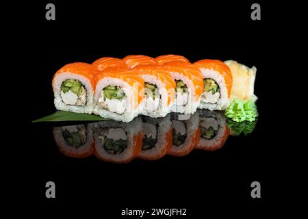 Sushi-Sets Uramaki, Kalifornien, Philadelphia, auf einem weißen Teller. Festliches Neujahrskonzept. Vor einem dunklen reflektierenden Hintergrund. Stockfoto