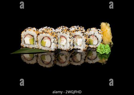 Sushi-Sets Uramaki, Kalifornien, Philadelphia, auf einem weißen Teller. Festliches Neujahrskonzept. Vor einem dunklen reflektierenden Hintergrund. Stockfoto