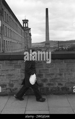 Ein Fabrikarbeiter geht nach einer Tagesschicht in der Salze Cotton Mill nach Hause. Salts Mill, benannt nach Sir Titus Salt, wurde 1986 nach 133 Jahren als Textilfabrik geschlossen. Saltaire, Bradford. HOMER SYKES AUS DEN 1981 1980ER JAHREN Stockfoto