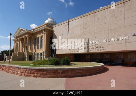 Guthrie, Oklahoma - 16. September 2021: Oklahoma Territorial Museum, Carnegie Library und Statehood Statue. Auf der East Oklahoma Ave. Stockfoto