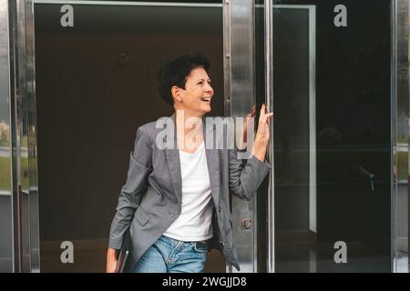 Glückliche Frau, Die Das Gebäude Verlässt Stockfoto