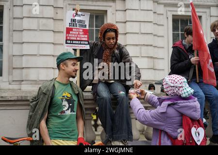 Eine Frau verteilt Süßigkeiten, während Hunderttausende auf dem Nationalmarsch für Palästina in London marschierten und einen dauerhaften Waffenstillstand in Gaza forderten. Stockfoto