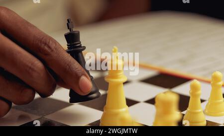 Ein Nahaufnahme-Porträt eines Schwarzen Mannes, der tief in Gedanken das Schachbrett während eines strategischen Spiels analysiert Stockfoto