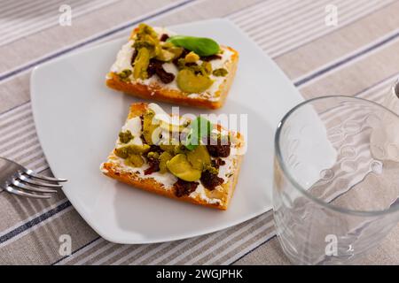 Getoastete Sandwiches mit Frischkäse, sonnengetrockneten Tomaten und Oliven Stockfoto