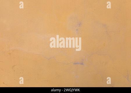 Gelb-orange Stuckwand, Textur, abblätternde Farbe. Hintergrund Stockfoto