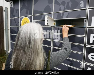 Frau, die Pakete verschickt und Artikel zurücksendet. Stockfoto