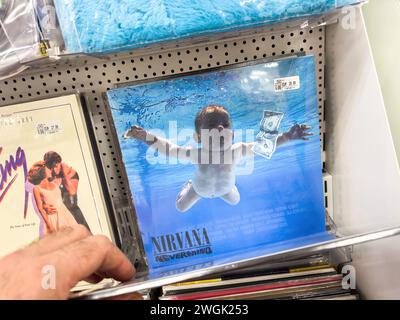 Berlin, Deutschland - 18. Januar 2024: Kunden durchsuchen Musikalben, ikonisches Baby Schwimmen für Dollar-Albumcover. Stockfoto