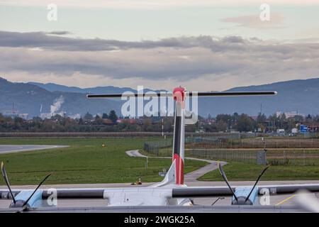 Flugzeugheck eines Flugzeugs und Propeller nähern sich vor dem Hintergrund einer kleinen Stadt. Heckflügel des Flugzeugs. Stockfoto