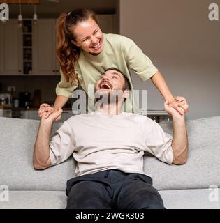 Das junge glückliche kaukasische Paar hat während des Wochenendes zu Hause Spaß. Valentinstag. Stockfoto