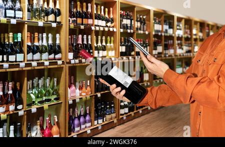 E-Label auf Weinflasche im Spirituosengeschäft zum Scannen von Verbrauchern. Stockfoto
