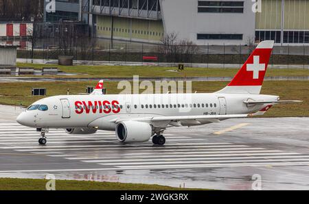 Ein Airbus A220-100 von Swiss International Airlines wartet auf der Startbahn 28 des Flughafens Zürich auf die Startfreigabe aus dem Kontrollturm. Regi Stockfoto