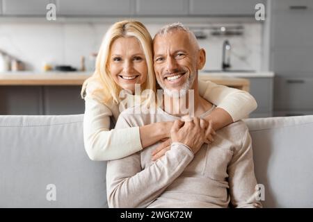 Liebe schöne ältere Frau, die ihren Mann umarmt, Inneneinrichtung Stockfoto