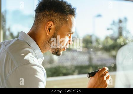 Geschäftsmann schreibt Ideen an das Fenster, während er an einem neuen Projekt arbeitet. Business- und Brainstorming-Konzept. Stockfoto