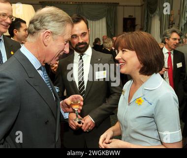 Aktenfoto vom 02/09 des damaligen Prinzen von Wales (heute König Charles III), der mit der Marie Curie Krankenschwester Catherine Le Roy aus Bristol während eines Empfangs für die Marie Curie Cancer Care, deren Schirmherr er ist, im Clarence House in London sprach. Der König wurde mit einer Form von Krebs diagnostiziert und hat einen Zeitplan für regelmäßige Behandlungen begonnen, und obwohl er öffentliche Aufgaben verschoben hat, bleibt er „seiner Behandlung vollkommen positiv“, sagte Buckingham Palace. Ausgabedatum: Montag, 5. Februar 2024. Stockfoto