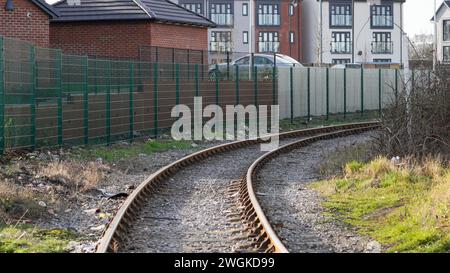 Barry Dock Regeneration: Alte Gleise verlaufen hinter der neuesten Phase neuer Häuser am East Quay. Der Standort befindet sich am Rand des Industriegeländes Stockfoto