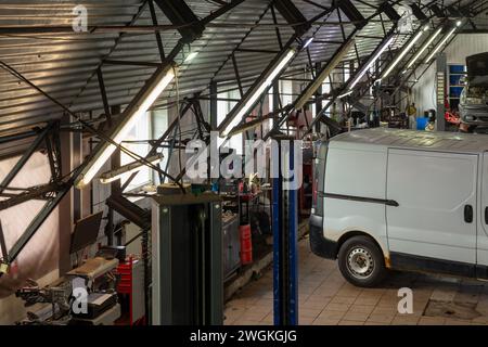 Autos im Kfz-Reparaturzentrum. Moderne Autoreparaturstation mit einer großen Anzahl von Aufzügen und spezieller Ausrüstung für Diagnose und Service Stockfoto