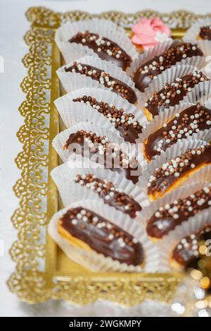 Kleine Eclairs Süßigkeiten Backgebäck mit bunten Streuseln aus der Nähe von Partyessen Stockfoto