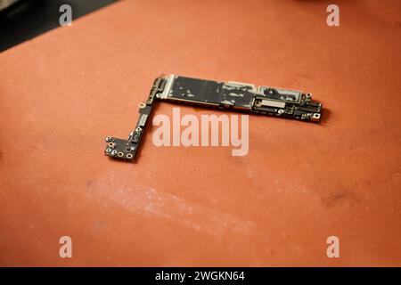 Elektronisches Mikroschema defekter elektronischer Geräte auf dem Tisch in der Reparaturwerkstatt, Kleinbetrieb Stockfoto