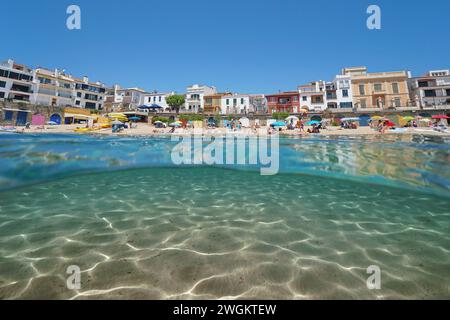 Spanien, Strand im mediterranen Dorf Calella de Palafrugell von der Meeresoberfläche mit Sand unter Wasser, geteilter Blick zur Hälfte über und unter Wasser Stockfoto