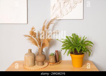 Vasen mit Pampas Gras und Pflanzen auf dem Tisch im Wohnzimmer Stockfoto