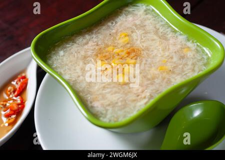 Hühnermaissuppe in einer grünen Schüssel serviert. Warmes Frühstück, geeignet für kalte Temperaturen Stockfoto