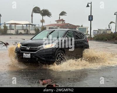 Montecito, Kalifornien, USA. Februar 2024. Ein Auto überquert das gefährliche Hochwasser im Shoreline Park in Santa Barbara während der Überschwemmung. (Kreditbild: © Amy Katz/ZUMA Press Wire) NUR REDAKTIONELLE VERWENDUNG! Nicht für kommerzielle ZWECKE! Stockfoto